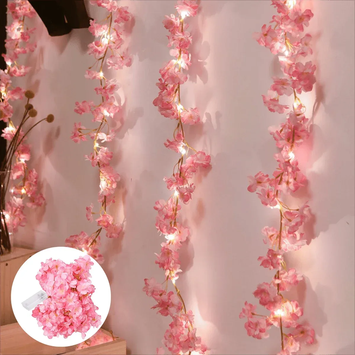 Pink cherry blossom garland with fairy lights on a table