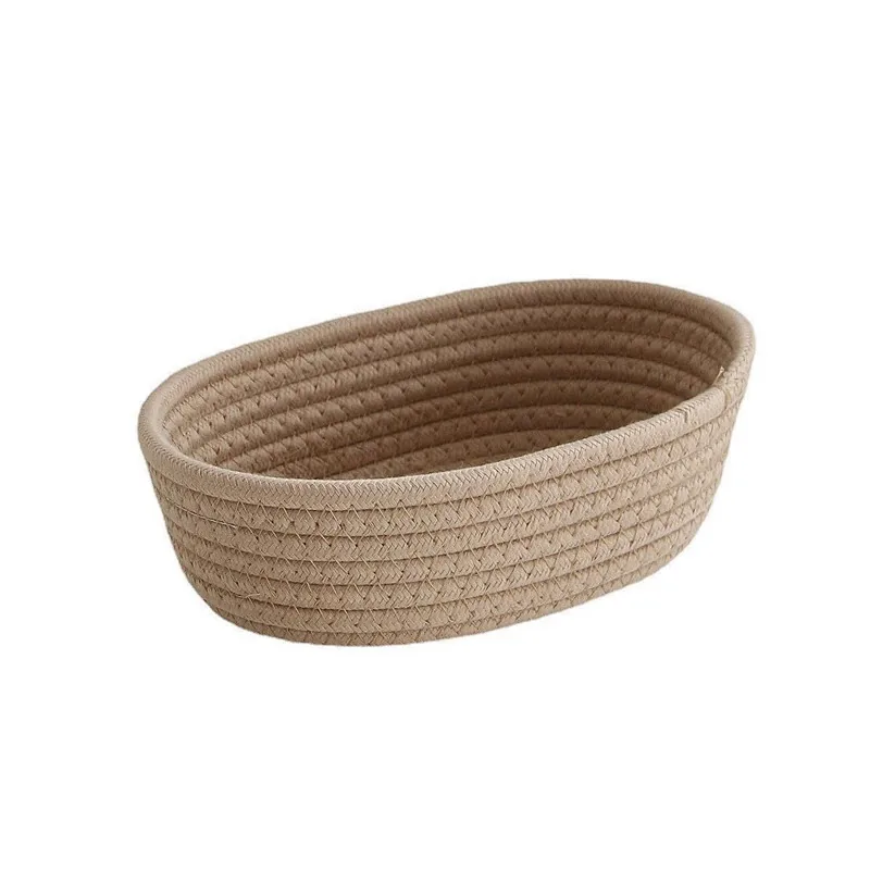 Oval woven cotton rope storage basket in sand